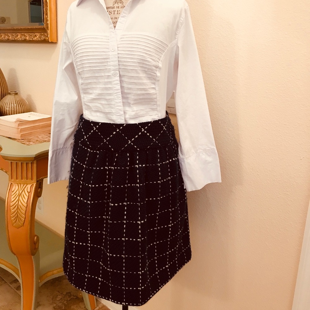 - Navy blue skirt with white stitching.